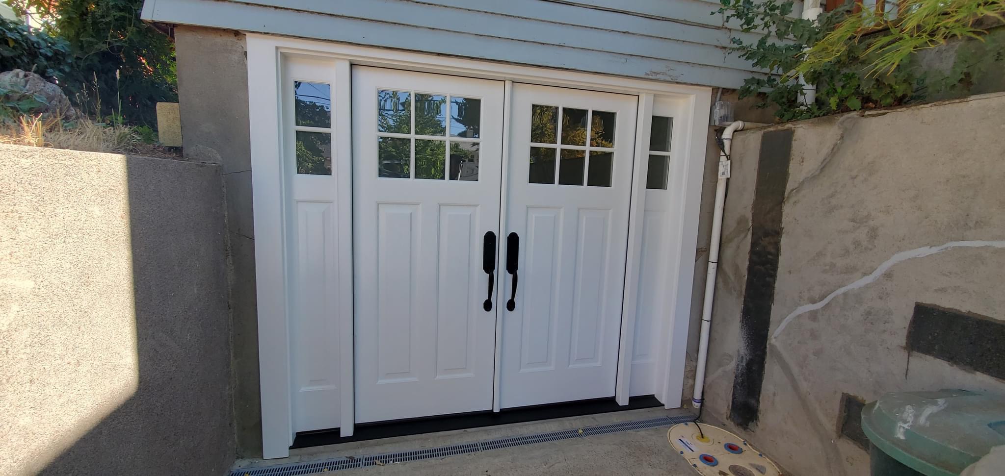 White carriage style garage doors installed and painted